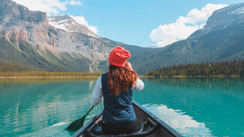 Frau fährt Kajak auf dem Emerald Lake im Banff-Nationalpark