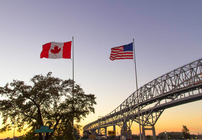 Kanadische und US-amerikanische Flagge an der Grenze