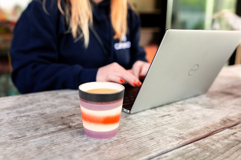 Frau mit Laptop und Kaffeetasse