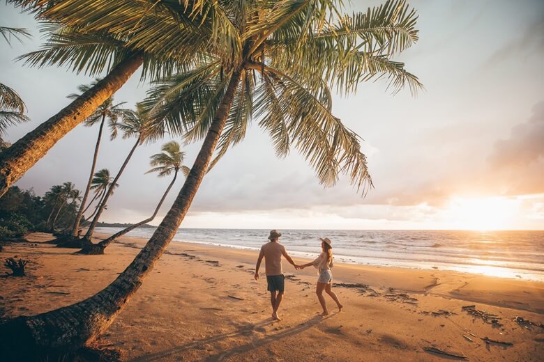 Pärchen rennt über den Mission Beach bei Sonnenuntergang 