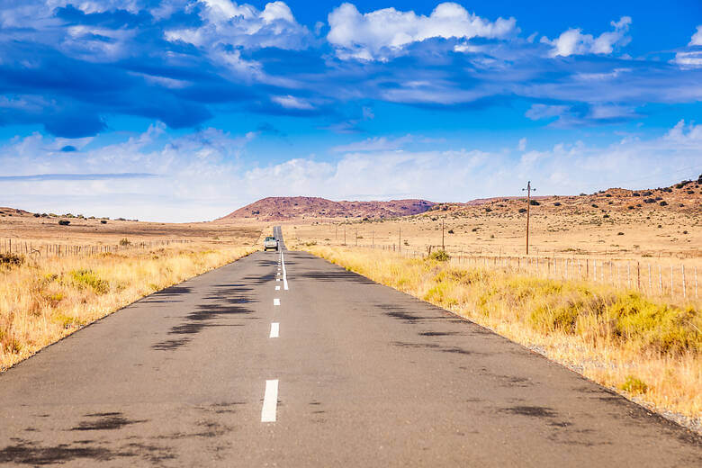 Camper fährt durch Wüstenlandschaft in Südafrika am Ostkap