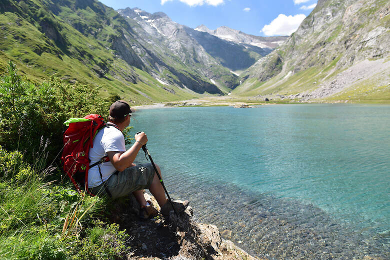 Wanderer macht eine Pause an einem Bergesee in den Pyrenäen