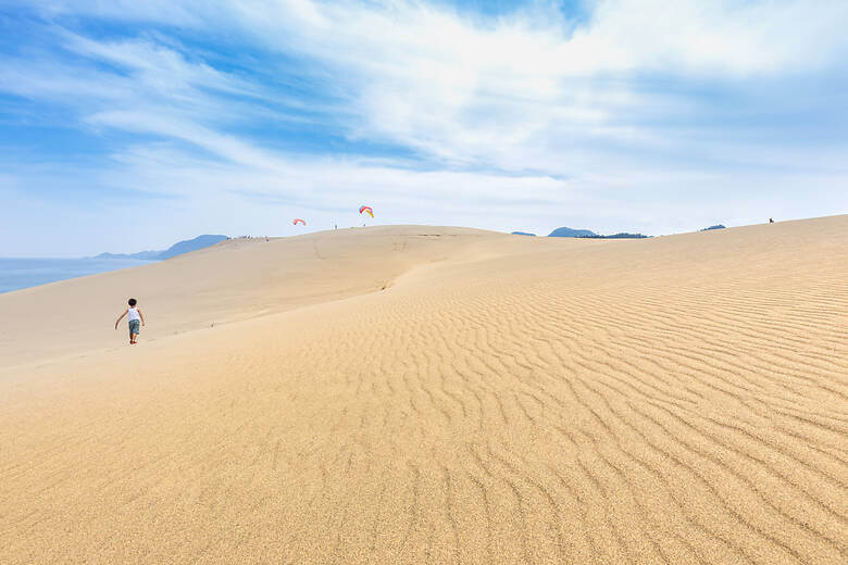 Kind läuft über die Tottori-Sanddünen im Westen von Japan