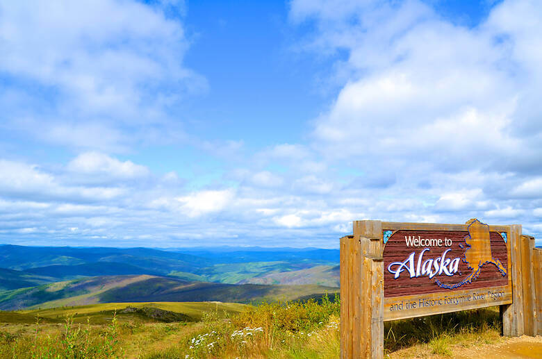 Willkommensschild in Alaska auf dem Highway.