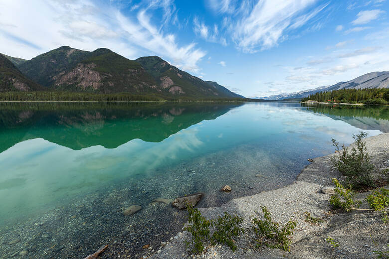 Reflektionen am blauen Muncho Lake in Alaska.